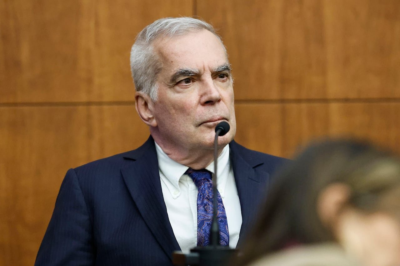 default-276 Grey haired man in blue suit looking serious as he testifies in court