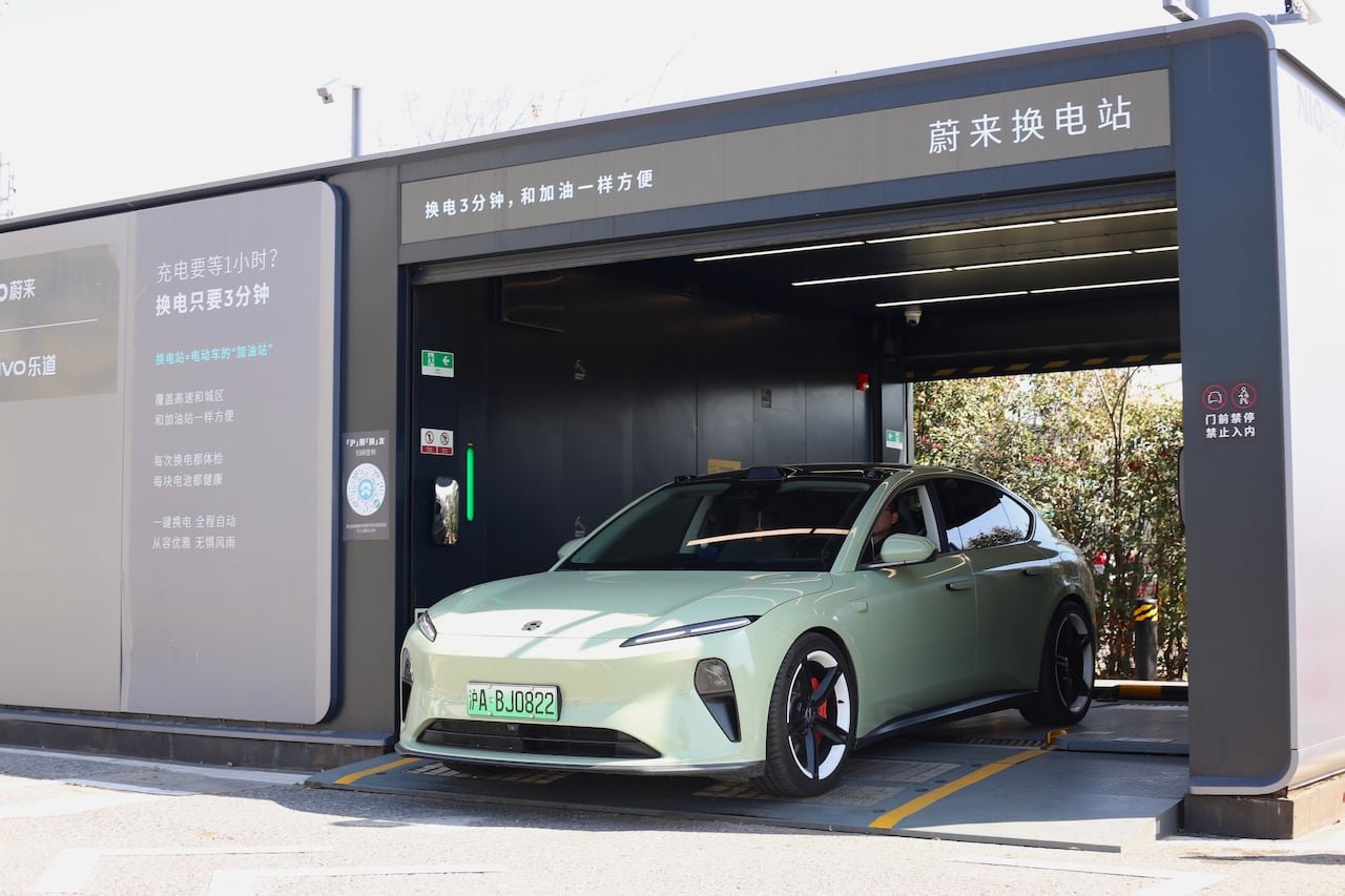 default-77 A pale green car sits inside a grey, garage-like structure.